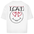 Das Oversize Shirt Operation Love White von State Your Mind zeigt einen fetten "OPERATION LOVE" Rückenprint und ein großes skizzenhaftes Smiley-Gesicht mit roten Herzaugen auf dem Rücken.