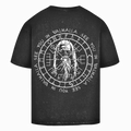 Das Printegy Oversize Shirt Valhalla Black washed zeigt einen weißen nordischen Krieger, Runen, kreisförmige Wikingerkompass-Symbole und den wiederholten Text "SEE YOU IN VALHALLA" auf einem schwarz gewaschenen T-Shirt.